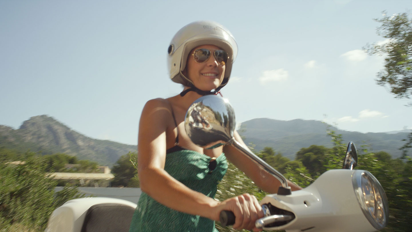 Frau auf einer Vespa in den Bergen von Port de Sóller