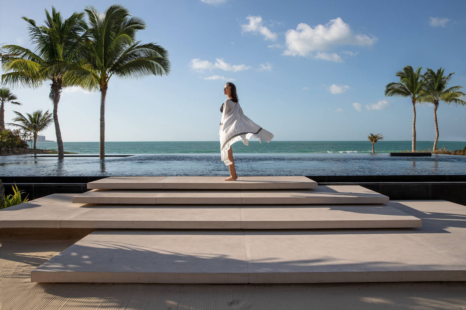 Woman standing at Jumeirah Al Qasr's infinity pool